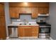 Close-up of the kitchen featuring wood cabinets, stainless steel appliances, and marble countertops at 4020 Alden Ave, Indianapolis, IN 46221