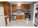 Kitchen showcasing wood cabinets, stainless steel appliances, and updated tile flooring at 4020 Alden Ave, Indianapolis, IN 46221