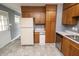 Spacious kitchen featuring wood cabinets, white appliances, and updated tile flooring at 4020 Alden Ave, Indianapolis, IN 46221