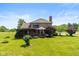 A large, well-maintained backyard shows off a brick house with a cozy covered deck, perfect for outdoor relaxation at 4287 Gibbs Rd, Danville, IN 46122