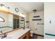 Well-lit bathroom with large mirror, double sinks, wall shelves, wood-look flooring and bathtub/shower combo at 4287 Gibbs Rd, Danville, IN 46122