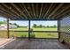 The backyard and lawn offer picturesque views from the wood deck framed by decorative lattice and a charming wood railing at 4287 Gibbs Rd, Danville, IN 46122