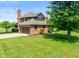 Brick home with attached garage, a well-maintained lawn, and beautiful mature landscaping at 4287 Gibbs Rd, Danville, IN 46122