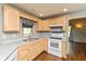 Kitchen sink and stove area with wood cabinets and a window at 4287 Gibbs Rd, Danville, IN 46122