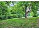 A spacious backyard with lush green grass and mature trees provides a serene outdoor setting at 4570 Moccosin Pl, Greenwood, IN 46142