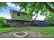 Home backyard with firepit, a deck, brick and vinyl siding, framed by lush foliage at 4570 Moccosin Pl, Greenwood, IN 46142
