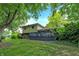 A backyard with a large wooden deck, surrounded by brick and vinyl siding and mature trees at 4570 Moccosin Pl, Greenwood, IN 46142