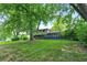 Home featuring a large deck and brick and vinyl siding, framed by large mature trees at 4570 Moccosin Pl, Greenwood, IN 46142
