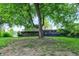Brick and vinyl home with a wooden deck and large backyard, framed by a mature tree at 4570 Moccosin Pl, Greenwood, IN 46142