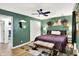 Bedroom featuring green walls, white trim, a large bed, ceiling fan, and wood floors at 4570 Moccosin Pl, Greenwood, IN 46142