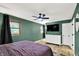 Bedroom with green walls, wood trim windows, ceiling fan, and white dresser and closet at 4570 Moccosin Pl, Greenwood, IN 46142