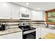 Contemporary kitchen with white cabinets, granite countertops, and stainless steel appliances at 4570 Moccosin Pl, Greenwood, IN 46142