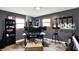 Office with gray walls, wood trim windows, musical instruments, and three monitors on desk at 4570 Moccosin Pl, Greenwood, IN 46142