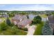 Aerial view of a two-story brick home with manicured landscaping and a tranquil lake nearby at 4617 S Cobblestone Dr, Zionsville, IN 46077