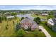Aerial view of a two-story brick home with a well-manicured lawn and a pool in the neighborhood at 4617 S Cobblestone Dr, Zionsville, IN 46077