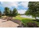 A brick patio with a fire pit overlooks a scenic pond in the backyard, a hot tub is nearby at 4617 S Cobblestone Dr, Zionsville, IN 46077