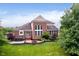 A brick two-story home features a patio with a hot tub and a brick fire pit in the backyard at 4617 S Cobblestone Dr, Zionsville, IN 46077