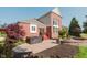 The brick backyard has a hot tub, fire pit, red stairs, a green lawn, and is partially surrounded by green trees at 4617 S Cobblestone Dr, Zionsville, IN 46077