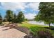 Scenic backyard showcasing lush greenery, landscaping, a firepit, and peaceful lake views at 4617 S Cobblestone Dr, Zionsville, IN 46077