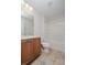Well-lit bathroom featuring shower-tub combination, tiled flooring, wood vanity with sink, and large mirror at 4617 S Cobblestone Dr, Zionsville, IN 46077