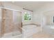 Bathroom featuring a large soaking tub and separate shower with glass door at 4617 S Cobblestone Dr, Zionsville, IN 46077