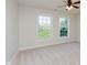 Bright bedroom with neutral carpet, ceiling fan, and two large windows overlooking green trees at 4617 S Cobblestone Dr, Zionsville, IN 46077