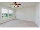 Comfortable bedroom with neutral carpet, a ceiling fan, and a large window view to the outside at 4617 S Cobblestone Dr, Zionsville, IN 46077