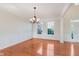 Formal dining room featuring hardwood floors, elegant chandelier, and wainscoting at 4617 S Cobblestone Dr, Zionsville, IN 46077