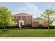 Beautiful two-story brick home with a manicured lawn and bright red front door at 4617 S Cobblestone Dr, Zionsville, IN 46077