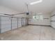 Spacious three-car garage with a concrete floor, white walls, and three windows for natural light at 4617 S Cobblestone Dr, Zionsville, IN 46077