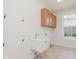 Functional laundry room with a utility sink, storage cabinets, and natural light at 4617 S Cobblestone Dr, Zionsville, IN 46077