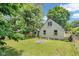 The backyard features a lush lawn, fire pit, trees, and a charming green house with fenced yard at 4708 Haverford Ave, Indianapolis, IN 46205