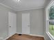 Bedroom featuring two doors and a window, with neutral paint and wood floors at 4708 Haverford Ave, Indianapolis, IN 46205