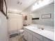 Well-lit bathroom features a wide mirror, white cabinets, and a shower with neutral curtain at 4992 Fennel Dr, Pittsboro, IN 46167