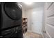 Efficient laundry room showcasing a modern, stacked washer and dryer with storage shelves at 4992 Fennel Dr, Pittsboro, IN 46167