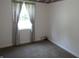 Bedroom with a window, neutral carpet, and floral print curtains at 509 Eberhart Dr, Shelbyville, IN 46176