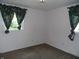 Bedroom featuring neutral carpet and two windows with floral curtains at 509 Eberhart Dr, Shelbyville, IN 46176