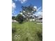 Well-maintained lawn with mature trees, a garden, and a view of the home's back exterior at 5304 Appleseed Way, Indianapolis, IN 46217