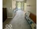 Open living area with neutral carpeting and a bench at 5304 Appleseed Way, Indianapolis, IN 46217
