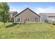 Spacious backyard featuring a wooden deck, mature tree, and healthy green lawn, ideal for outdoor activities and relaxation at 5409 Brandywine Dr, Whitestown, IN 46075