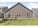 Rear of house with a wooden deck and sliding glass door leading to a well-maintained, verdant lawn at 5409 Brandywine Dr, Whitestown, IN 46075