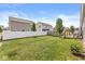 Spacious backyard with white privacy fence, green grass, and a small deck area at 5409 Brandywine Dr, Whitestown, IN 46075