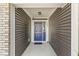 Inviting entryway with a striking blue front door, complemented by wood siding and a covered porch at 5409 Brandywine Dr, Whitestown, IN 46075