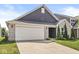 Stylish home with a brick and siding exterior, a two-car garage, and a well-maintained lawn, providing a welcoming curb appeal at 5409 Brandywine Dr, Whitestown, IN 46075