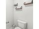 A half bathroom featuring a standard white toilet and decorative wooden shelves at 5409 Brandywine Dr, Whitestown, IN 46075