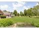 Backyard with garden beds, playset, and charming brick and blue home at 5695 N Red Oak Dr, Greenfield, IN 46140
