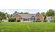 Expansive backyard featuring lush green grass, mature trees, and a home with blue and brick facade at 5695 N Red Oak Dr, Greenfield, IN 46140