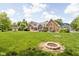 Expansive backyard with a fire pit, swing set, and charming brick home at 5695 N Red Oak Dr, Greenfield, IN 46140