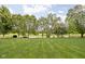 Expansive backyard with mature trees leading to a scenic body of water at 5695 N Red Oak Dr, Greenfield, IN 46140