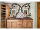 Close up of a double vanity with wood cabinets, vessel sinks, mirrors, and unique lighting fixtures at 5695 N Red Oak Dr, Greenfield, IN 46140
